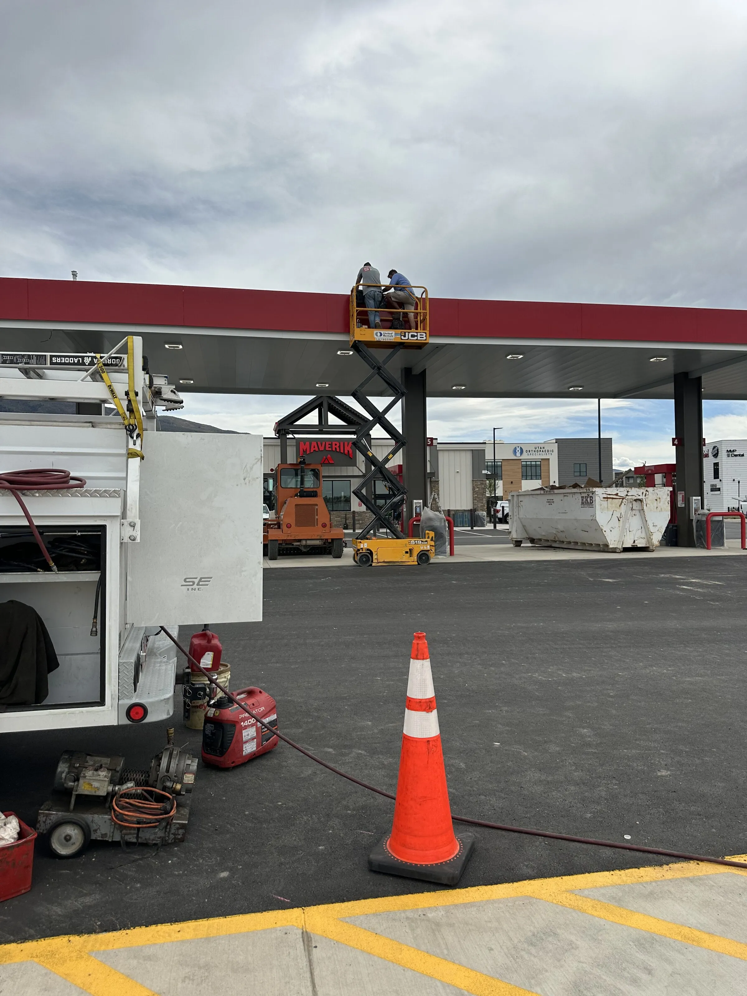 PTTI scissor lift crew working on a fueling canopy with the service truck and field equipment staged for UST compliance testing.